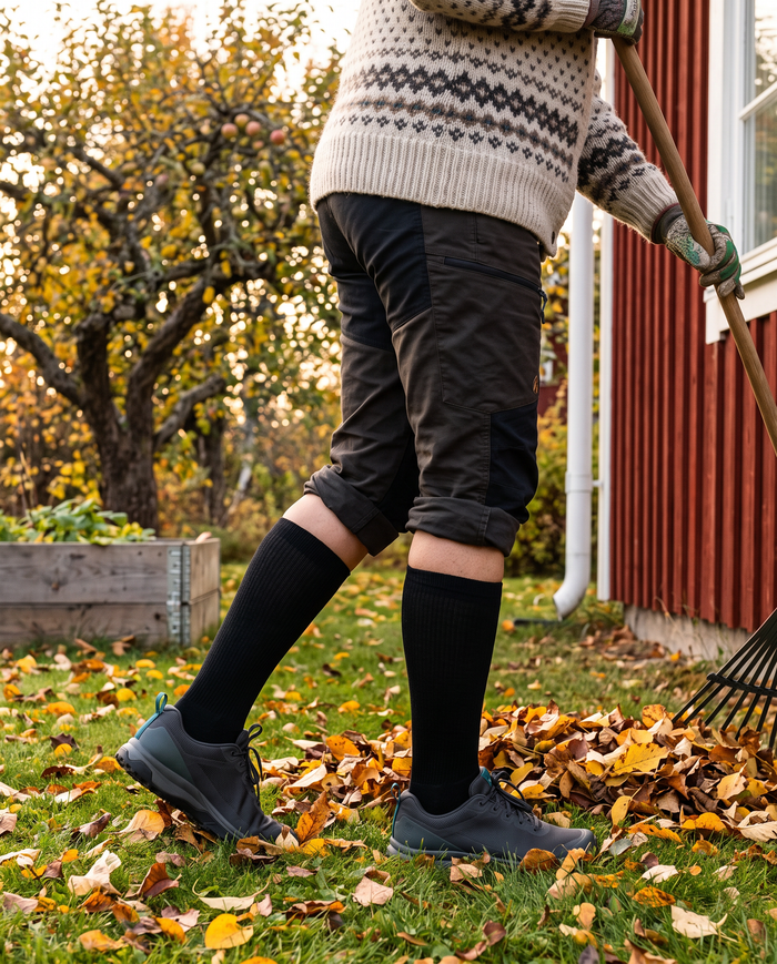 Kvinna som krattar löv i trädgården i Gococo Compression Wool